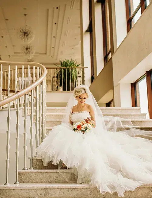 Bride holds a bouquet of flowers, adding a touch of romance to the scene. Photo by Andrew Bidylo